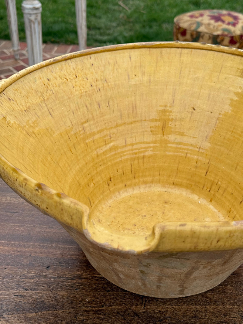 Close-up of an antique ceramic terra cotta glazed bowl with visible grain and texture on a blurred background