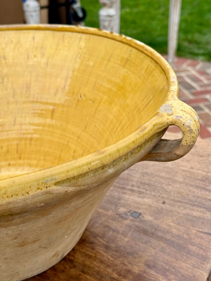 French 19th Century antique ceramic bowl with a handle on a wooden surface