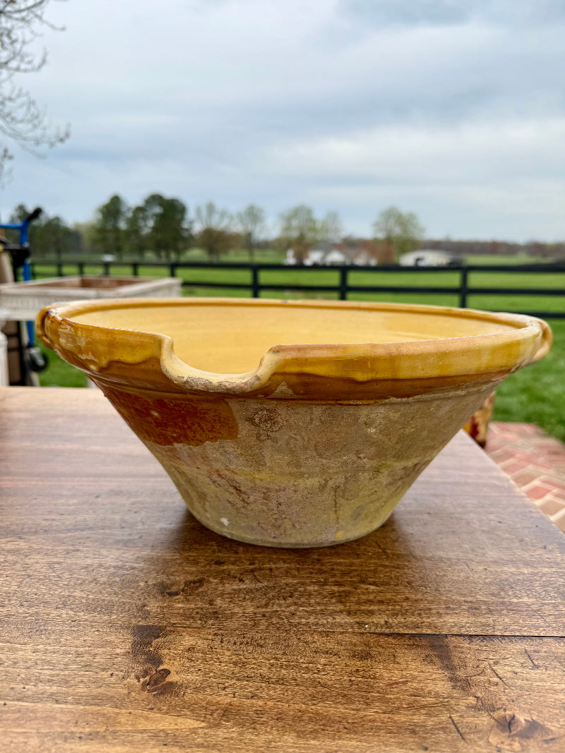 Classic 19th Century French Ceramic bowl with a brown glaze on a wooden surface outdoors