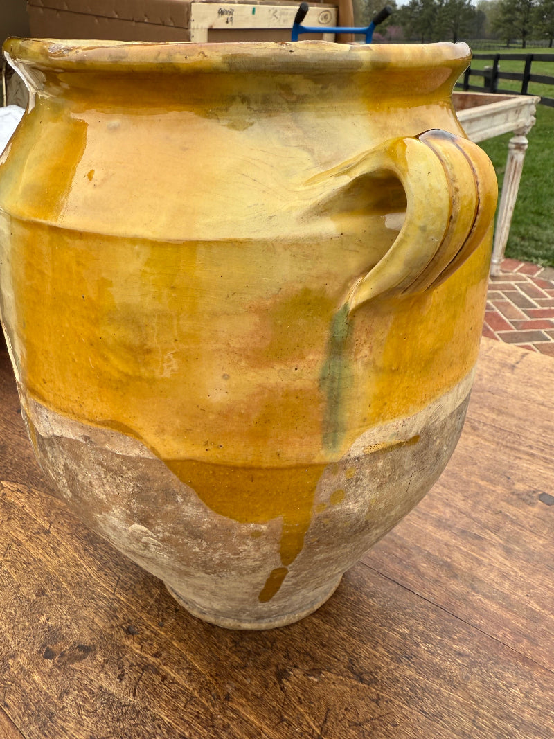 19th Century French Confit ceramic jar with a yellowish-brown glaze on a wooden surface