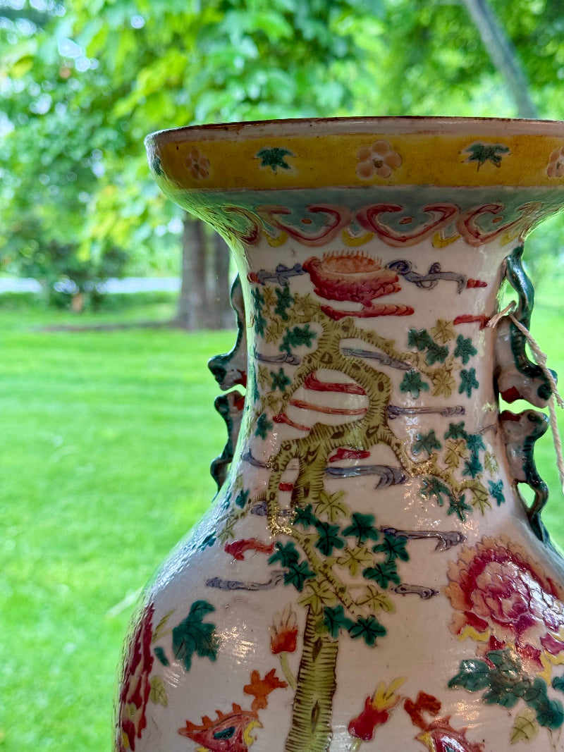 Decorative vase with colorful patterns against a blurred green outdoor background