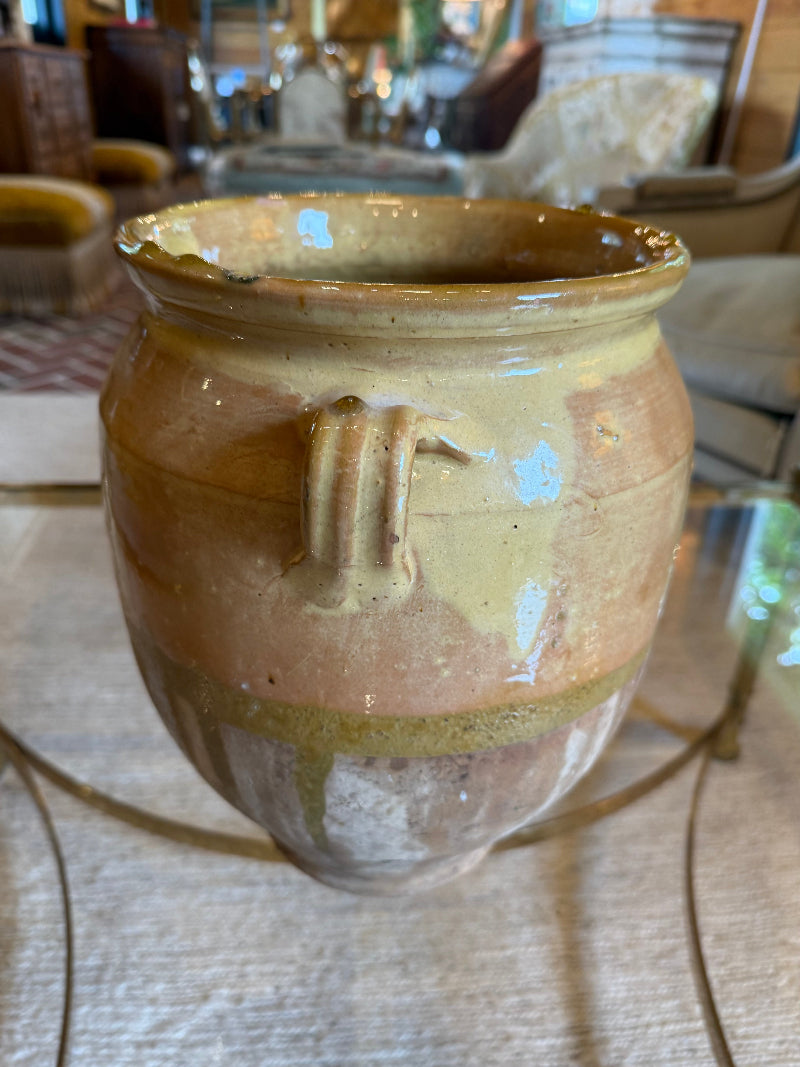 French Antique ceramic jar with a handle on a textured surface