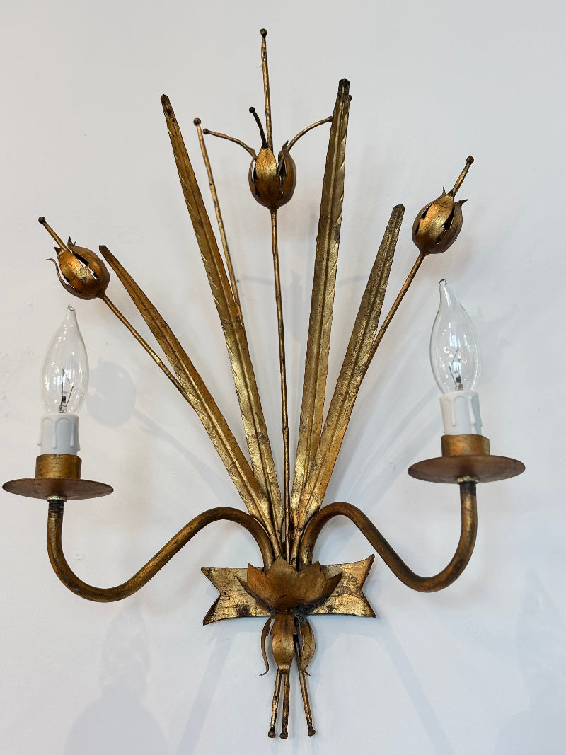 Decorative wall sconce with multiple arms and candle-like lights on a white background