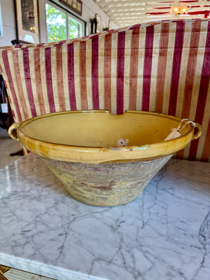 ANTIQUE French Glazed Yellow ceramic bowl on a marble surface with a striped fabric background
