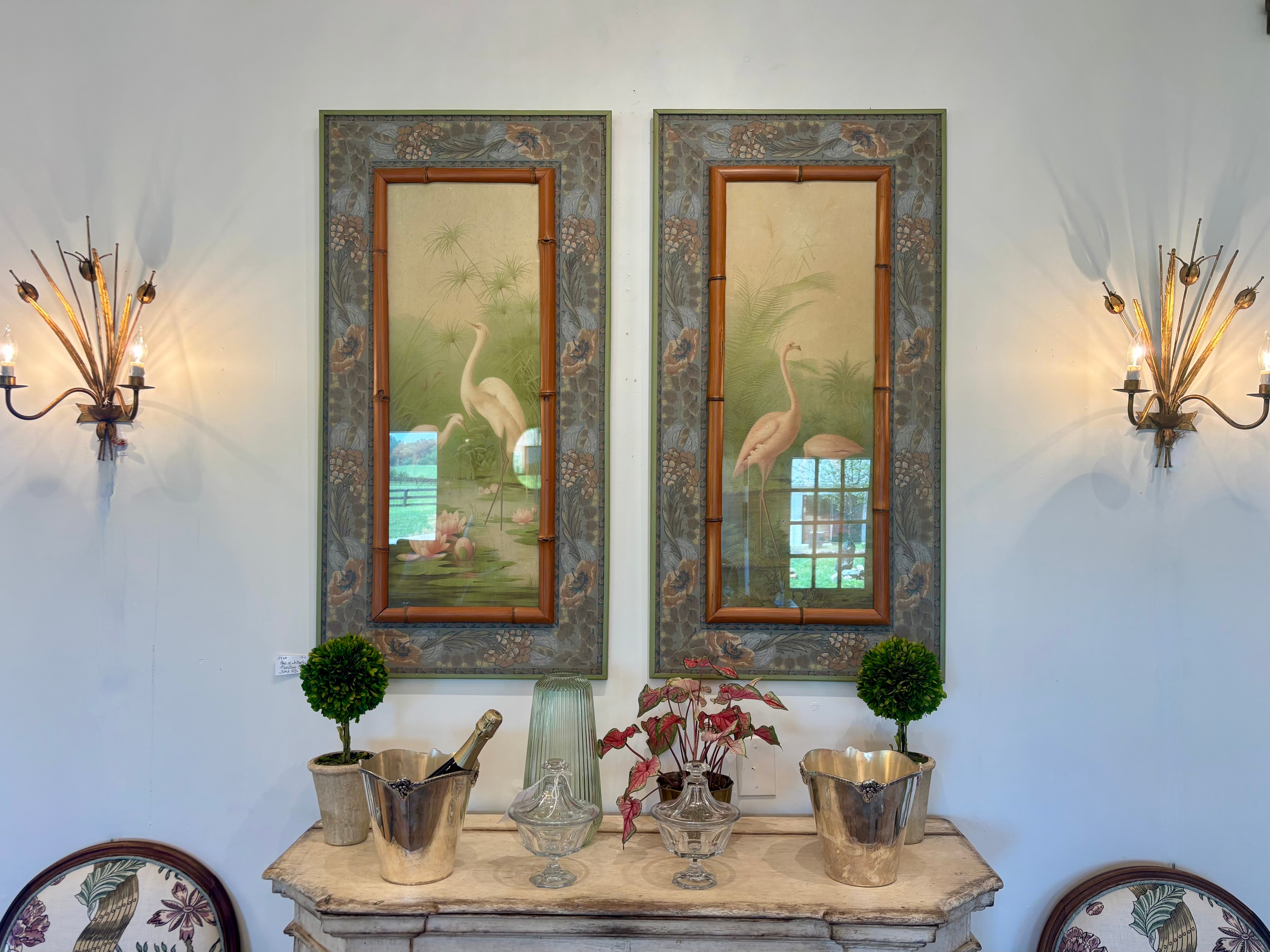 Two framed artworks of cranes on a wall with decorative elements.