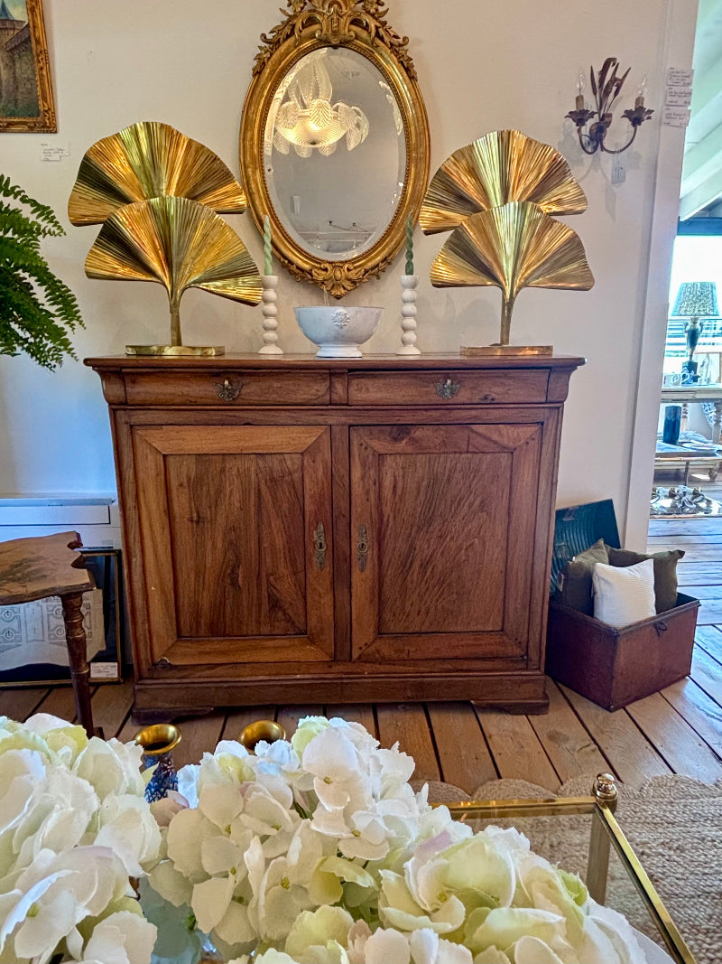 Antique French Walnut sideboard with gold leaf sculptures and a mirror in a room with flowers and furniture.