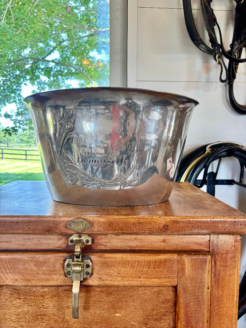 Silver CHAMPAgne or bucket on a wooden chest with a blurred outdoor background
