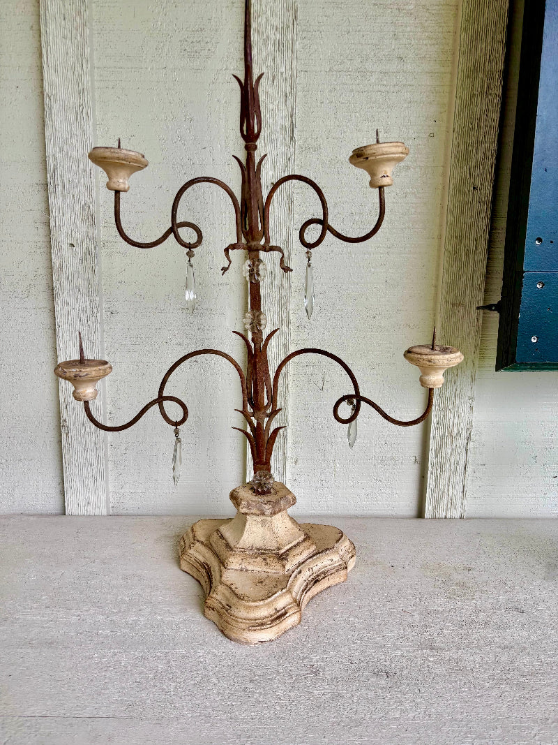 Decorative candelabra with a rustic design on a wooden floor.