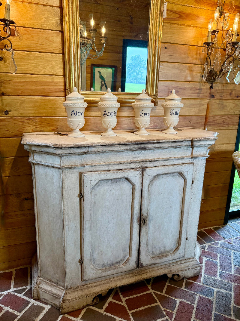  decorative apothecary jars against a wooden wall.