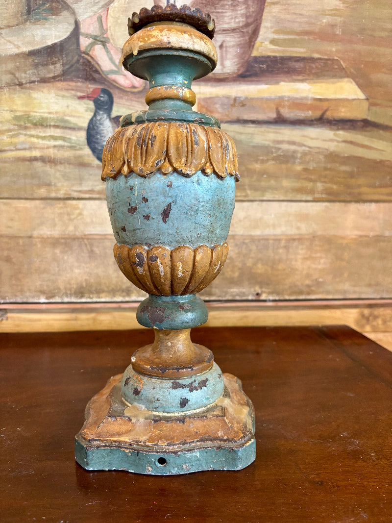 Italian wood candlestick with blue and gold patina on a wooden surface
