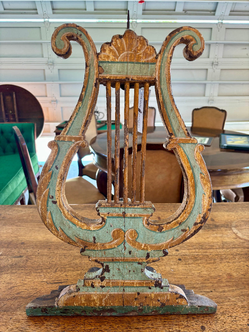Antique Decorative wooden lyre candlestick on a table with a blurred indoor background