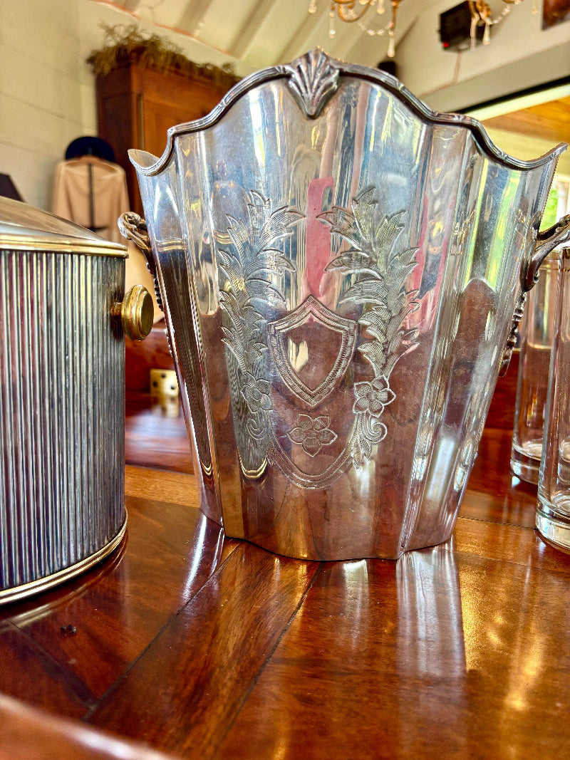Antique French silver champagne bucket with intricate designs on a wooden surface